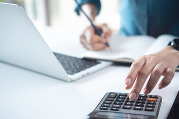 Weibliche Hand an einem Taschenrechner