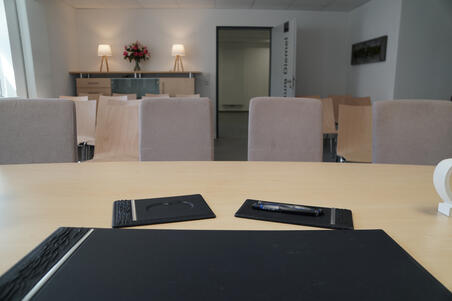 Auf dem Bild ist das Trauzimmer "Diemel" aus sicht des Standesbeamten zu sehen. Über den Tisch hinaus sind die Stuhlreihen und der Eingang zum Trauzimmer zu sehen.